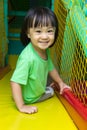 Happy Asian Chinese little girl playing slide at indoor playground Royalty Free Stock Photo