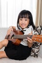 Happy Asian Chinese little girl playing ukele Royalty Free Stock Photo