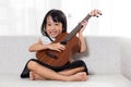 Happy Asian Chinese little girl playing ukele Royalty Free Stock Photo