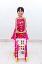 Happy Asian Chinese little girl pushing toy trolley Royalty Free Stock Photo