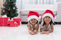 Happy Asian Chinese little sisters celebrate Christmas holiday a