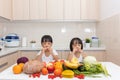 Happy Asian Chinese little sisters eating fruit and vegetable Royalty Free Stock Photo