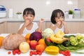 Happy Asian Chinese little sisters eating fruit and vegetable