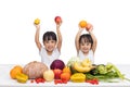 Happy Asian Chinese little sisters with fruit and vegetable