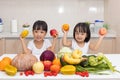 Happy Asian Chinese little sisters with fruit and vegetable Royalty Free Stock Photo