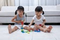 Happy Asian Chinese little sisters playing blocks on the floor Royalty Free Stock Photo