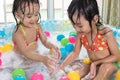 Happy Asian Chinese little sisters playing in the inflatable poo Royalty Free Stock Photo