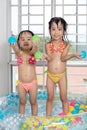 Happy Asian Chinese little sisters playing in the inflatable poo Royalty Free Stock Photo
