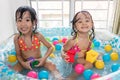 Happy Asian Chinese little sisters playing in the inflatable poo Royalty Free Stock Photo