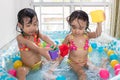 Happy Asian Chinese little sisters playing in the inflatable poo Royalty Free Stock Photo