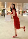 Happy Asian Chinese modern fashionable woman shopping bags in a mall store casual buyer smile laugh consumption on sale promotion