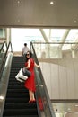 Happy Asian Chinese modern fashionable woman shopping bags in a mall store wear sunglasses casual buyer smile laugh elevator lift