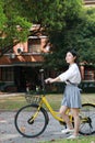 Happy Asian Chinese pretty girl riding a bike wear student suit in school Royalty Free Stock Photo