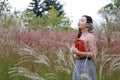 Happy Asian Chinese woman girl dream pray in flower field autumn fall park lawn hope nature read book knowledge freedom carefree Royalty Free Stock Photo