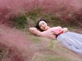 Happy Asian Chinese woman girl lying on grass dream pray flower field autumn fall park lawn hope nature read book knowledge