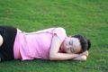 Happy Asian Chinese woman sleep on grass Royalty Free Stock Photo