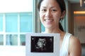 Close-up of Happy Asian Chinese Woman smiling sweetly from pregnancy news