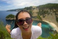 Happy Asian Chinese woman in sunglasses enjoying amazing coast scene from view point at tropical paradise beach with diamond rock Royalty Free Stock Photo