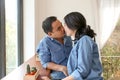 Happy Asian couple in blue jean kiss each other in a coffee shop Royalty Free Stock Photo