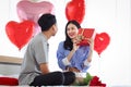 Happy Asian couple celebrate anniversary together, boyfriend give present gift box to surprised girlfriend who need hug him, Royalty Free Stock Photo