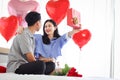 Happy Asian couple celebrate anniversary together, boyfriend give present gift box to surprised girlfriend who need hug him, Royalty Free Stock Photo