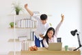 Happy Asian couple celebrating their new high sale after using computer laptop for online auction while working from home Royalty Free Stock Photo