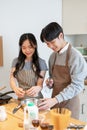 A happy Asian couple enjoy cooking time in the kitchen together. Girlfriend and boyfriend Royalty Free Stock Photo