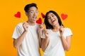 Happy asian couple holding red heart shaped cards Royalty Free Stock Photo