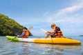 Happy asian couple kayaking together on the beautiful sea or canoe at tropical bay Royalty Free Stock Photo