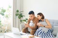 Happy Asian couple lover using mobile, laptop together at home Royalty Free Stock Photo