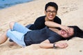 Happy asian couple lying down at beach Royalty Free Stock Photo