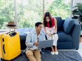 Happy Asian couple, man sit on floor and young woman on sofa, looking and using laptop computer. Royalty Free Stock Photo