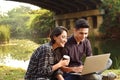 Happy asian couple sitting and surfing the net together Royalty Free Stock Photo