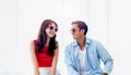 Happy Asian couple in summer, young man and woman wearing sunglasses with smile, sitting on the bed. Royalty Free Stock Photo