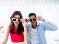 Happy Asian couple in summer, young man and woman wearing sunglasses and touching it and looking at camera . Royalty Free Stock Photo