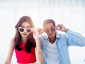 Happy Asian couple in summer, young man and woman wearing sunglasses and touching it and looking at camera. Royalty Free Stock Photo