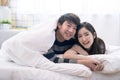 Happy Asia couple teasing each other on the bed in the bedroom.