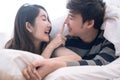 Happy Asia couple teasing each other on the bed in the bedroom.