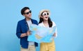 Happy Asian couple tourist opening the map to travel on summer holiday isolated on blue background