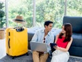 Happy Asian couple, young man and woman looking each other while using laptop computer. Royalty Free Stock Photo