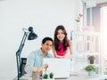 Happy Asian couple, young man and woman using tablet and laptop computer together. Royalty Free Stock Photo