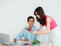 Happy Asian couple, young man and woman using tablet and laptop computer together for flight booking. Royalty Free Stock Photo