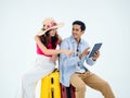 Happy Asian couple, young woman with beach hat and man in denim shirt sit on suitcase. Royalty Free Stock Photo