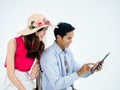 Happy Asian couple, young woman with beach hat and man in denim shirt using tablet together for trip information. Royalty Free Stock Photo