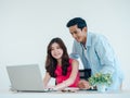 Happy Asian couple, young woman and man using tablet and laptop computer together. Royalty Free Stock Photo