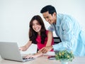 Happy Asian couple, young woman and man using tablet and laptop computer together. Royalty Free Stock Photo