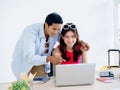 Happy Asian couple, young woman using laptop computer on desk together. Royalty Free Stock Photo