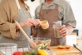 Happy Asian couples, husband and wife, are cooking a healthy salad bowl in the kitchen together Royalty Free Stock Photo