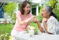 Happy Asian daughter have lunch whit her family and feeding salad to mother in backyard Royalty Free Stock Photo