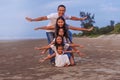 Happy Asian diversity generation family having fun together with open arms on tropical beach at summer. Royalty Free Stock Photo